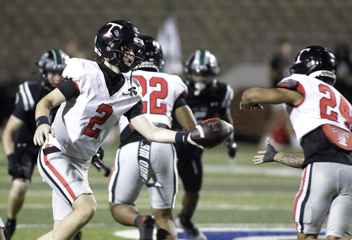 Euless Trinity quarterback Mack Lineweaver hands off to J.T. Harris against Mansfield Lake Ridge during their Class 6A Division I bi-district game on Friday, November 14, 2025 at Newsom Stadium in Mansfield Texas.