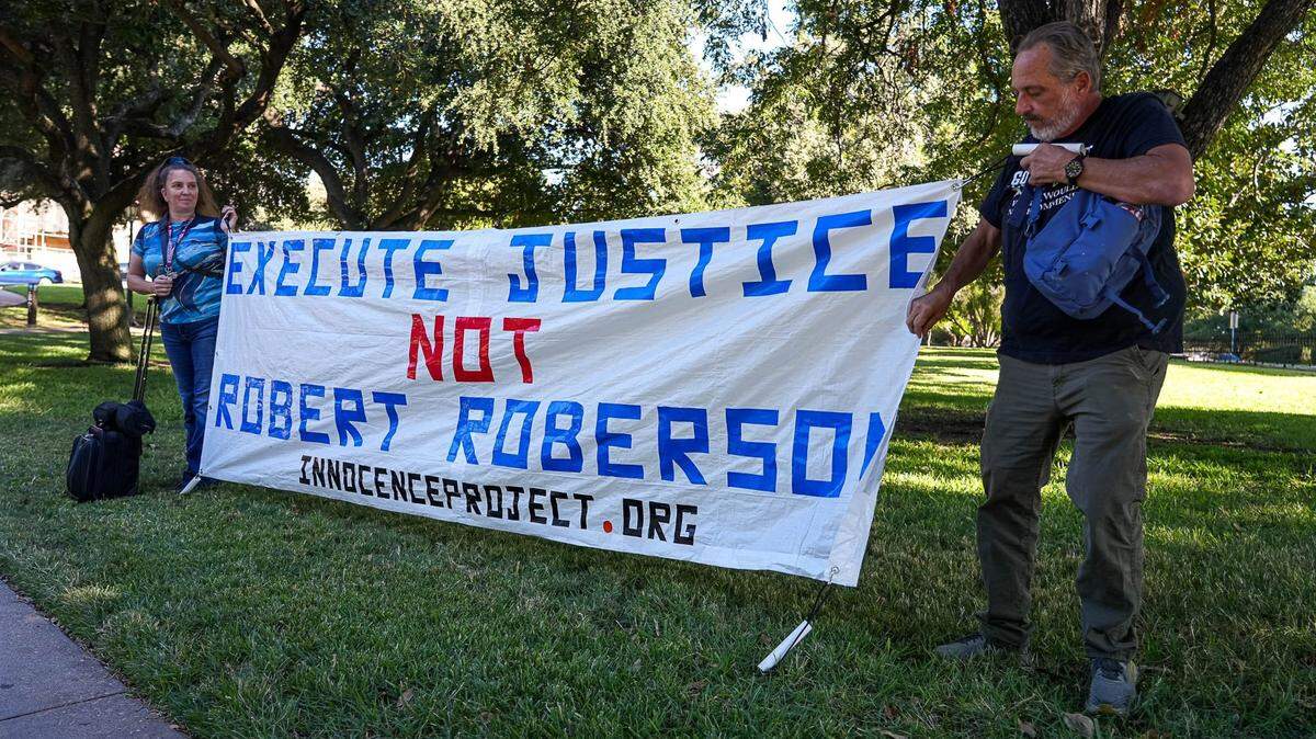 Amy Hedtke, left, and Bob Smilie, right, protest the execution of Robert Roberson ahead of a hearing with the Texas House of Representatives Committee on Judiciary and Civil Jurisprudence at the Texas Capitol on Monday, Oct. 24, 2024.