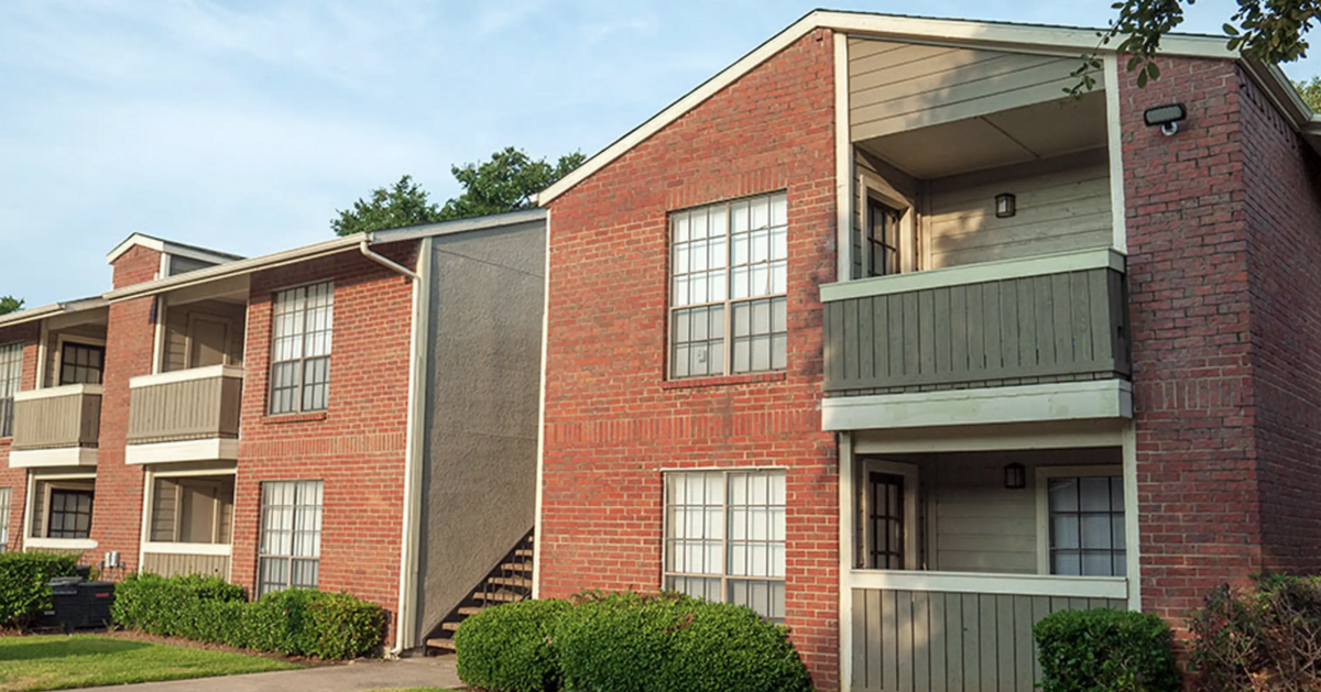 An exterior view of the Bridge Hollow Apartments shows a two-story multifamily apartment building.