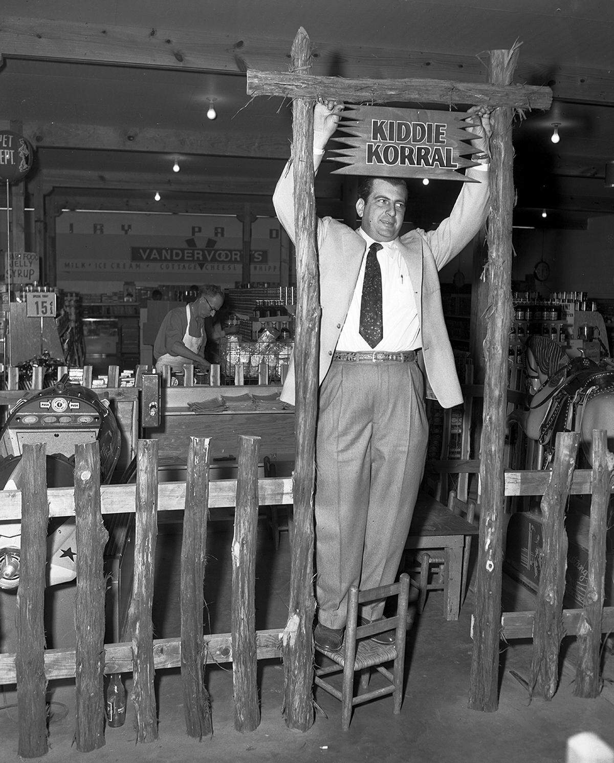 Dec. 18, 1952: Bill Meillmier, owner of Bill’s Food Store at 3701 E. Rosedale, hangs sign “Kiddie Korral” where children will have free access to mechanical riders, a horse and a spaceship. (The site today is a Family Dollar at Rosedale and South Ayers Avenue.)