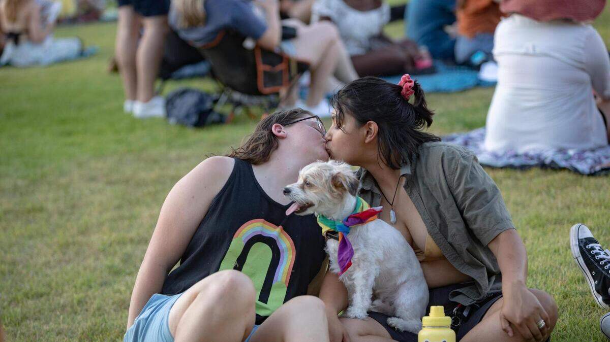 Lindy Jenkins and Jada Bustamante share a kiss before a performance begins during Trinity Pride at Magnolia Green Park on Saturday, June 25, 2022.