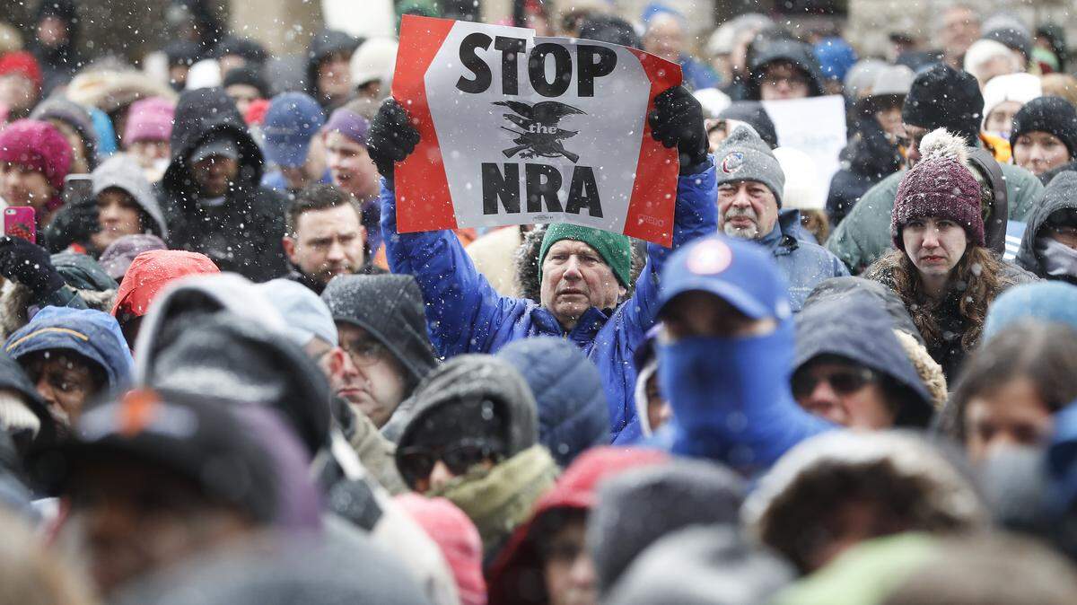 A demonstrator holds a "STOP the NRA" sign outside city hall during the "March for Our Lives" protest for gun legislation and school safety, Saturday, March 24, 2018, in Cincinnati. Students and activists across the country planned events Saturday in conjunction with a Washington march spearheaded by teens from Marjory Stoneman Douglas High School in Parkland, Fla., where over a dozen people were killed in February.