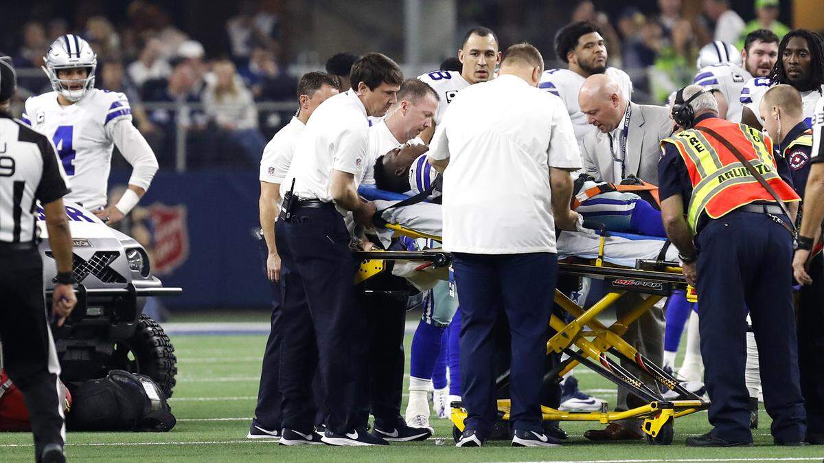 Cowboys quarterback Day Prescott, left, watches as teammate Allen Hurns is taken off the field on a stretcher during the NFL Wild Card playoff game at AT&T Stadium in Arlington, TX, Saturday, Jan. 5, 2019.