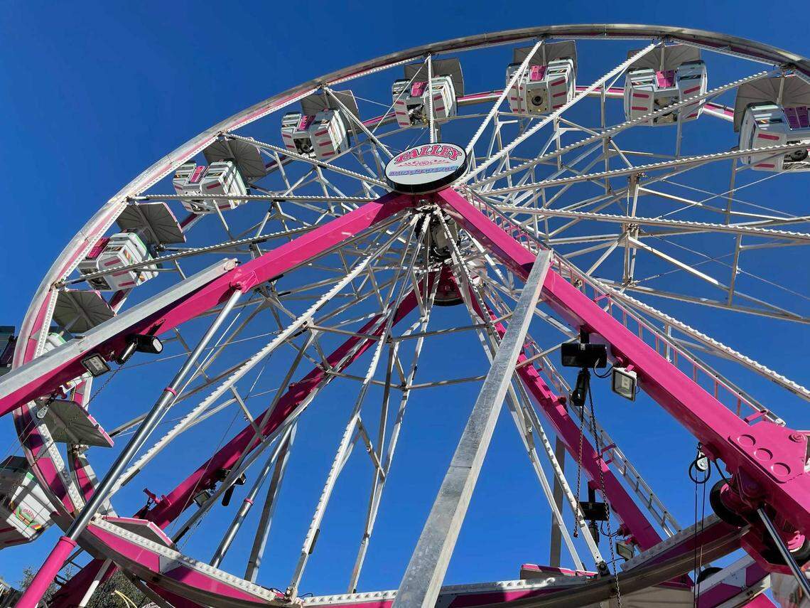 The carnival next door to the exhibition halls getting ready for the throngs waiting to ride the Ferris wheel.