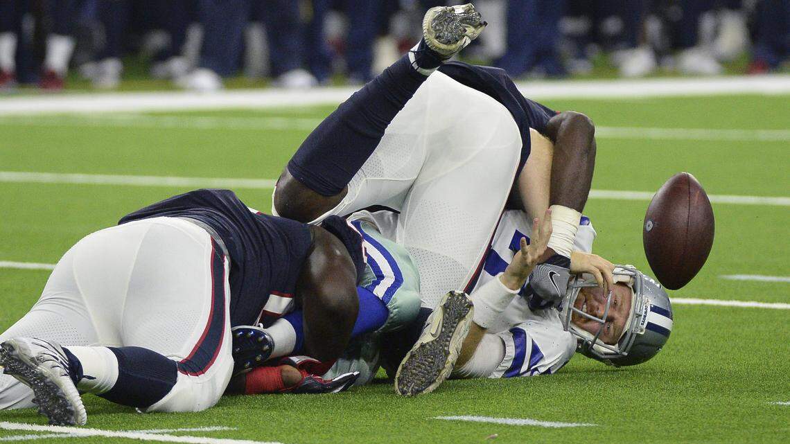 Dallas Cowboys quarterback Cooper Rush (7) fumbles the ball as he is hit by Houston Texans defenders Kingsley Opara, left, and Ufomba Kamalu, center, during the first half of a preseason NFL football game Thursday, Aug. 30, 2018, in Houston. Houston recovered the fumble.