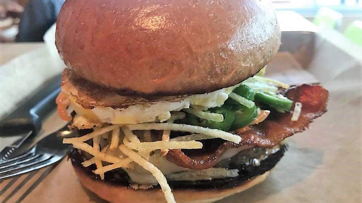 A spiced-up version of Hopdoddy Burger Bar's new breakfast burger, made with an Angus beef/breakfast sausage/ham patty, American cheese, scrambled eggs, potato hay and Applewood smoked bacon.