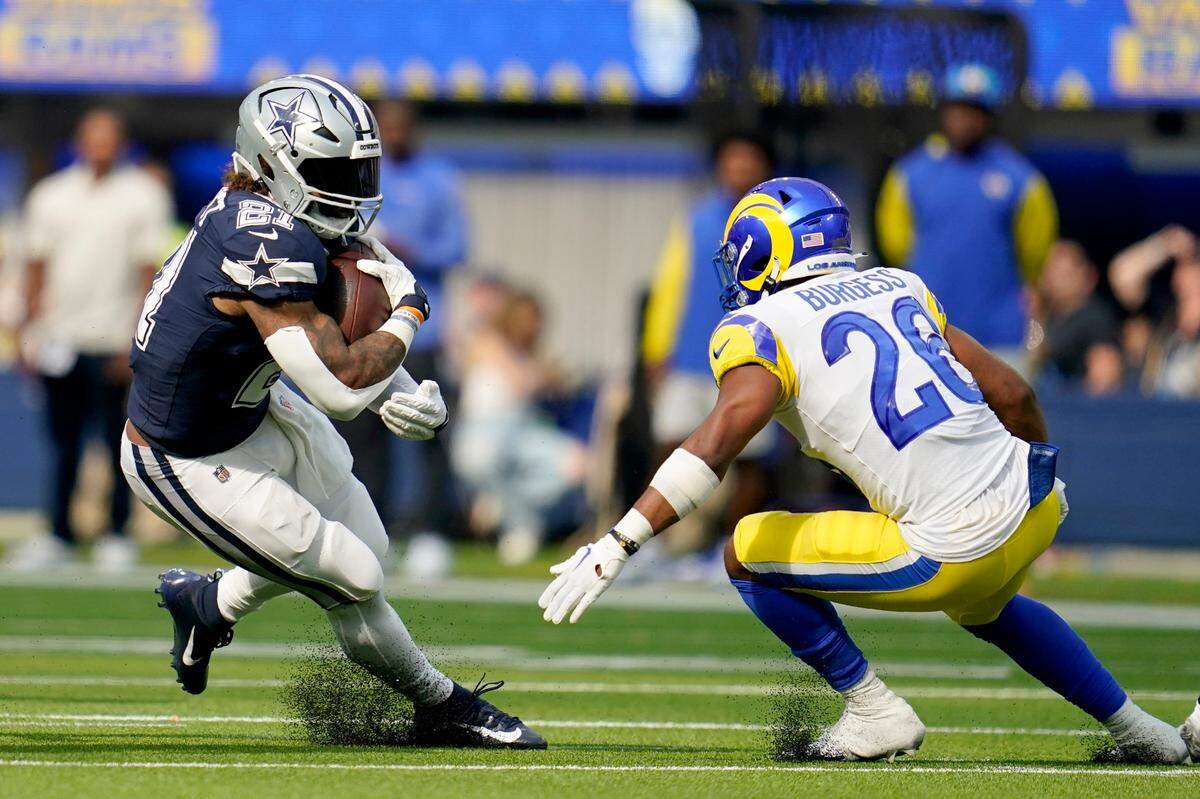 Dallas Cowboys running back Ezekiel Elliott (21) runs the ball as Los Angeles Rams safety Terrell Burgess (26) defends in the second half of an NFL football game, Sunday, Oct. 9, 2022, in Inglewood, Calif.