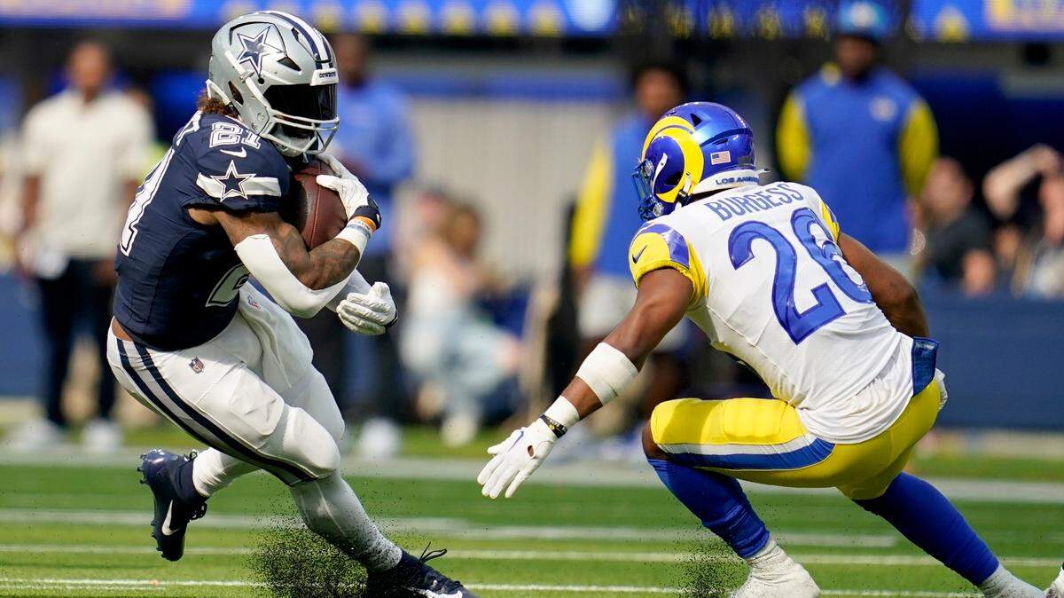 Dallas Cowboys running back Ezekiel Elliott (21) runs the ball as Los Angeles Rams safety Terrell Burgess (26) defends in the second half of an NFL football game, Sunday, Oct. 9, 2022, in Inglewood, Calif.