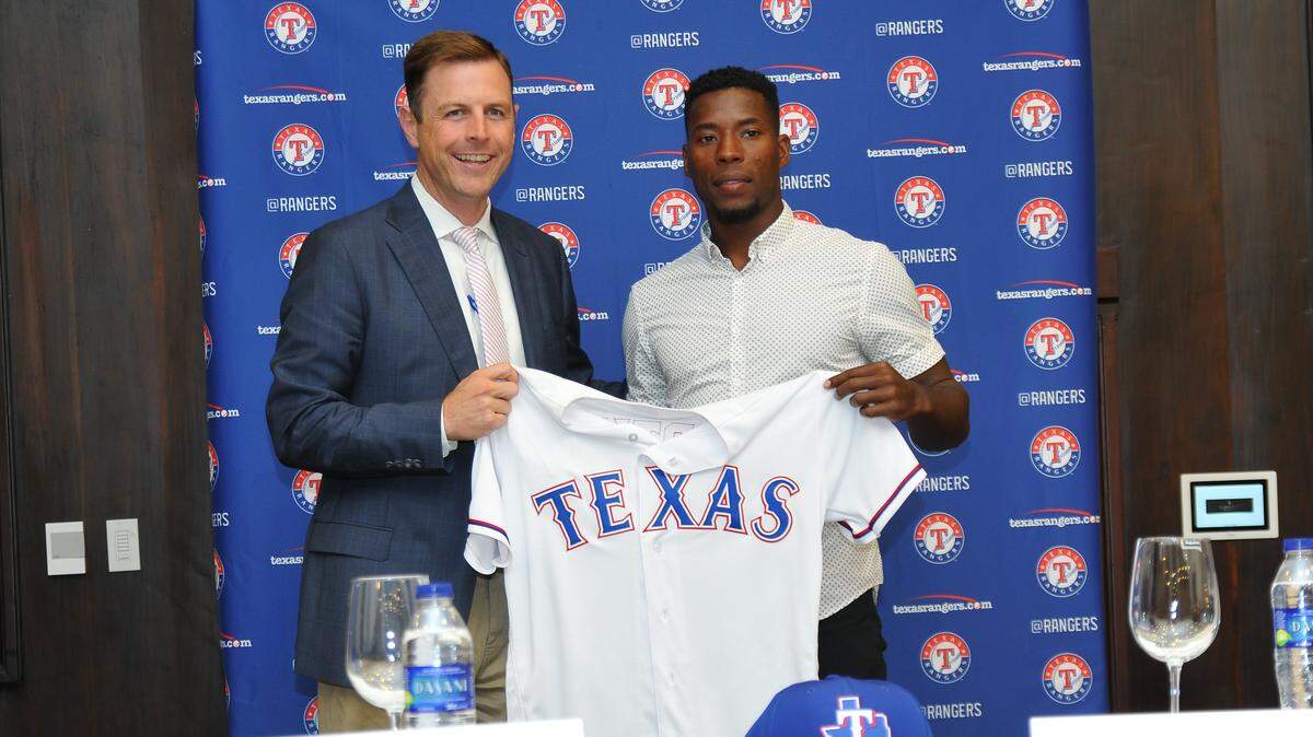 Texas Rangers assistant general manager Mike Daly, left, and Cuban outfielder Julio Pablo Martinez share a photo opportunity in April 2018 after Martinez signed a contract with the Rangers at a press conference in the Dominican Republic.