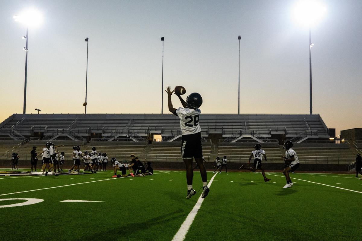 Linebacker Ryan Akpan reaches for the ball Monday, August 5, 2024, at Eagle Mountain High School. Players practiced drills focused on catching, fundamentals and team work.