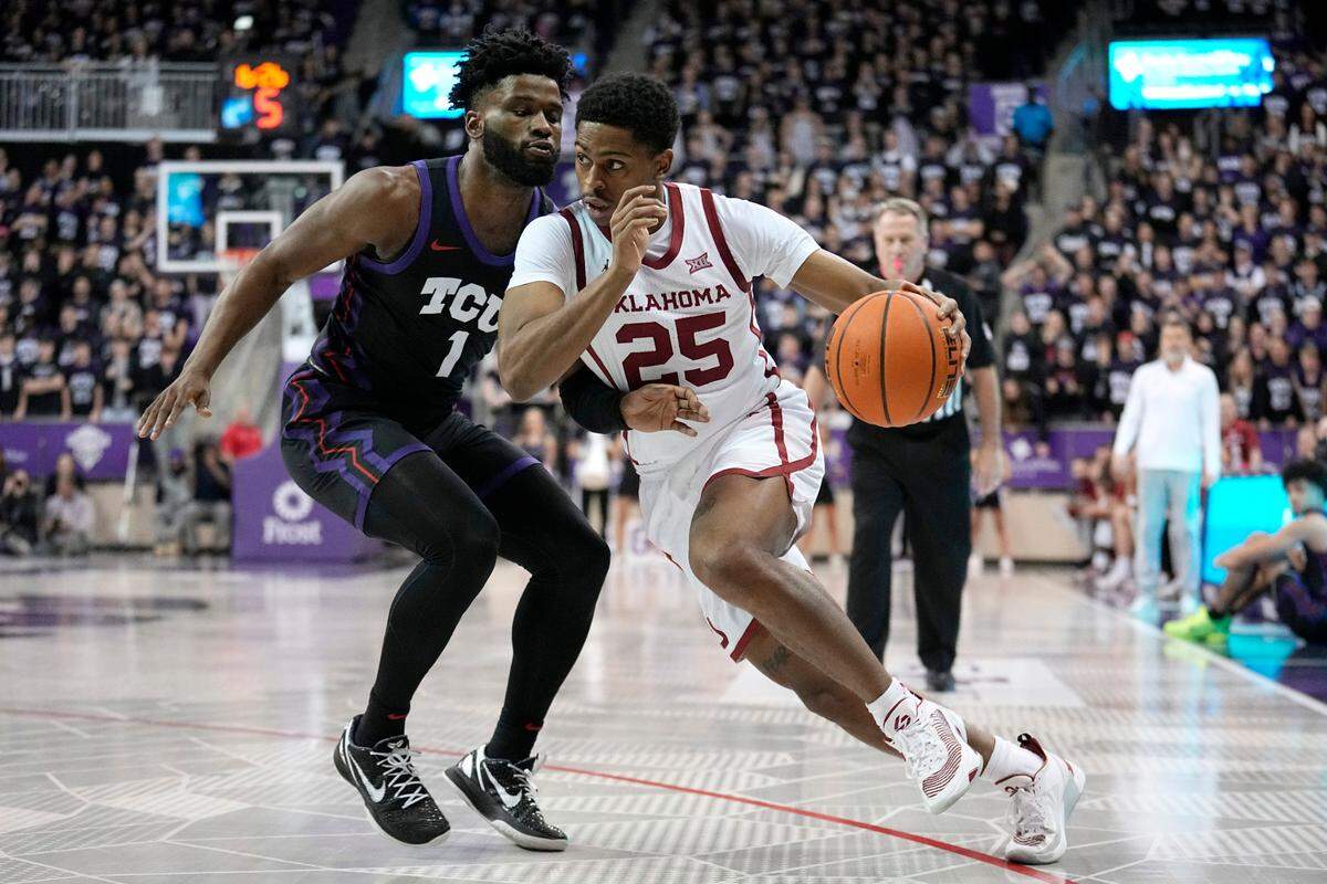 Oklahoma guard Grant Sherfield (25) works to the basket as TCU guard Mike Miles Jr. (1) defends in the first half of an NCAA college basketball game Tuesday, Jan. 24, 2023, in Fort Worth, Texas.