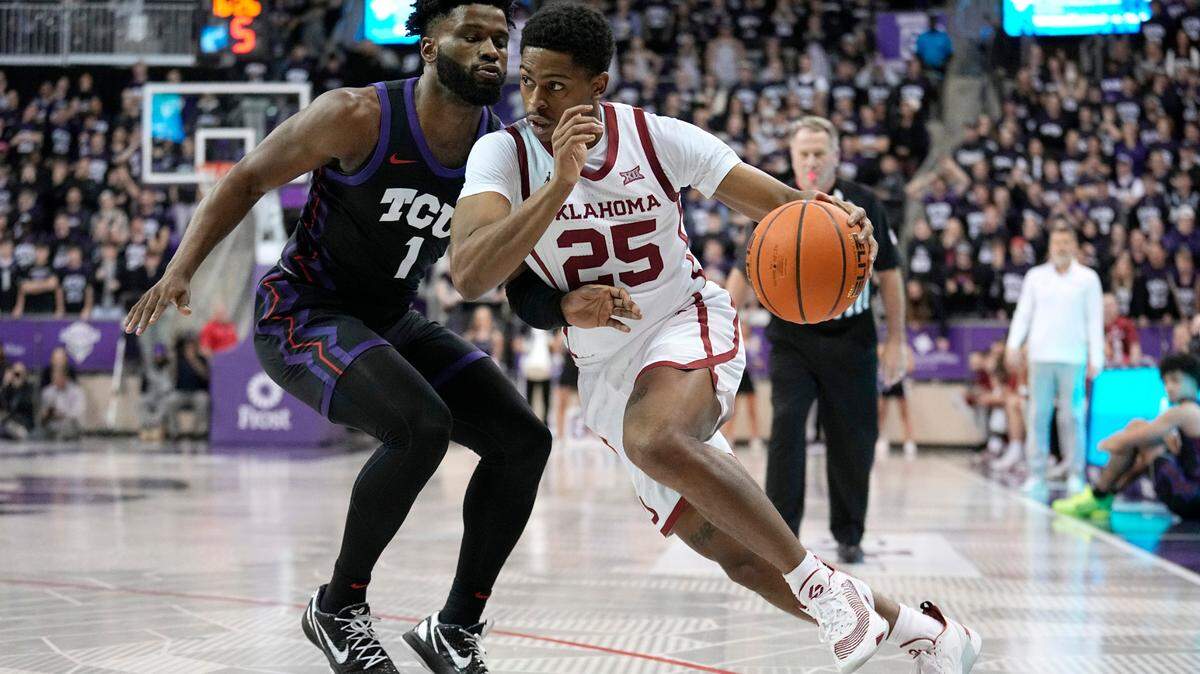 Oklahoma guard Grant Sherfield (25) works to the basket as TCU guard Mike Miles Jr. (1) defends in the first half of an NCAA college basketball game Tuesday, Jan. 24, 2023, in Fort Worth, Texas. (AP Photo/Tony Gutierrez)