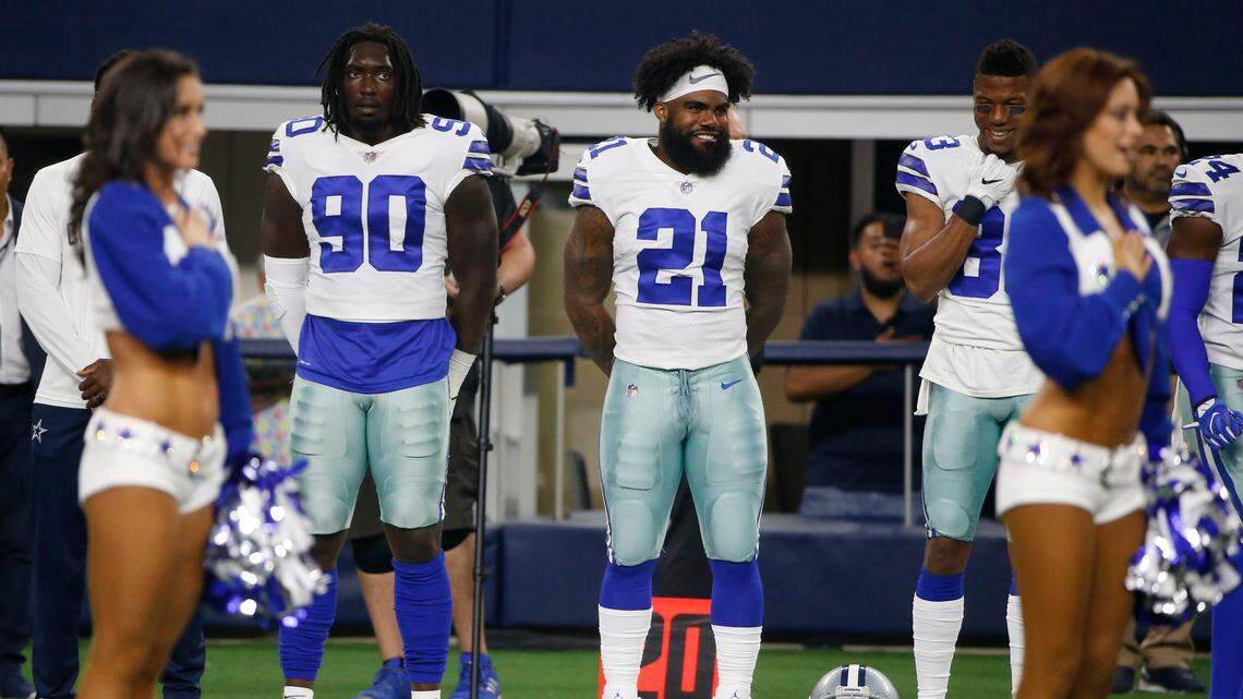 Dallas Cowboys defensive end Demarcus Lawrence, left, and running back Ezekiel Elliott stand during the anthem before a preseason game at AT&T Stadium on Aug. 18.