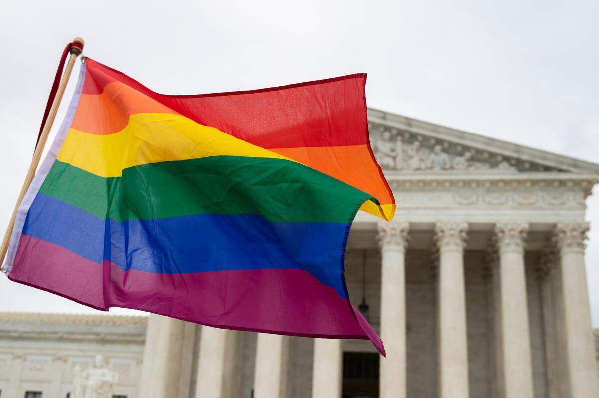 Supporters of the LGBT wave their flag in front of the U.S. Supreme Court, Tuesday, Oct. 8, 2019, in Washington. The Supreme Court is set to hear arguments in its first cases on LGBT rights since the retirement of Justice Anthony Kennedy. Kennedy was a voice for gay rights while his successor, Brett Kavanaugh, is regarded as more conservative. (AP Photo/Manuel Balce Ceneta)