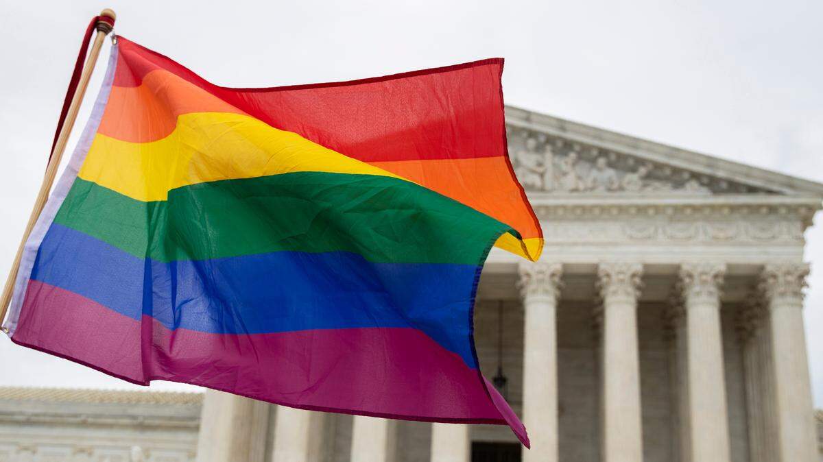 Supporters of the LGBT wave their flag in front of the U.S. Supreme Court, Tuesday, Oct. 8, 2019, in Washington. The Supreme Court is set to hear arguments in its first cases on LGBT rights since the retirement of Justice Anthony Kennedy. Kennedy was a voice for gay rights while his successor, Brett Kavanaugh, is regarded as more conservative. (AP Photo/Manuel Balce Ceneta)