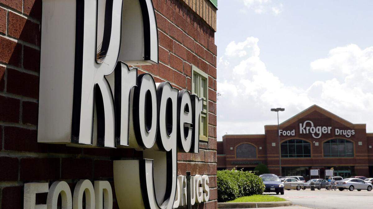 The Kroger road sign is visible in the foreground, and the brick grocery store building is in the background.