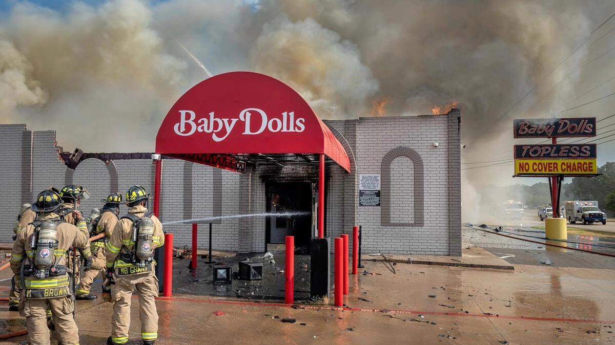 Firefighters battled a blaze at Baby Dolls, an adult entertainment club in far east Fort Worth, on Wednesday morning. The back wall and roof collapsed shortly after firefighters arrived, officials say.