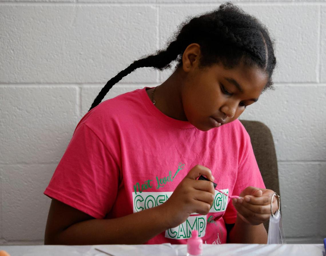 Kayniah Williams, 11, practices applying nail polish to nail blanks during Next Level Barber and Cosmo camp in Fort Worth, Texas on Thursday July 10, 2025.