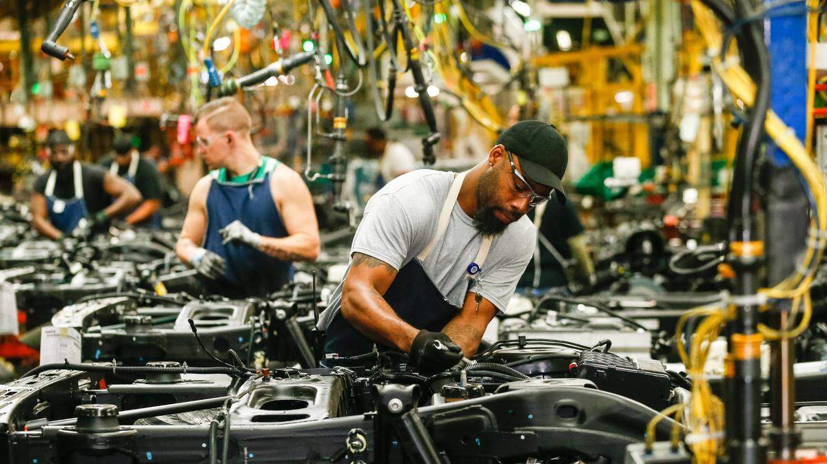 General Motors employees work on the assembly line at GM’s Arlington Assembly in 2019.