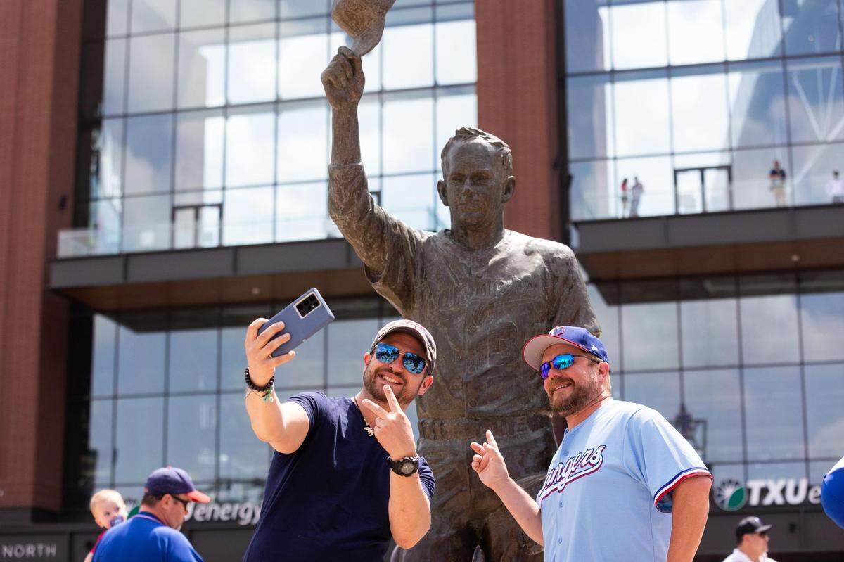Fans take photos before they enter the stadium for the Texas Rangers opening day game Monday, April 11, 2022, at Globe Life Field in Arlington.