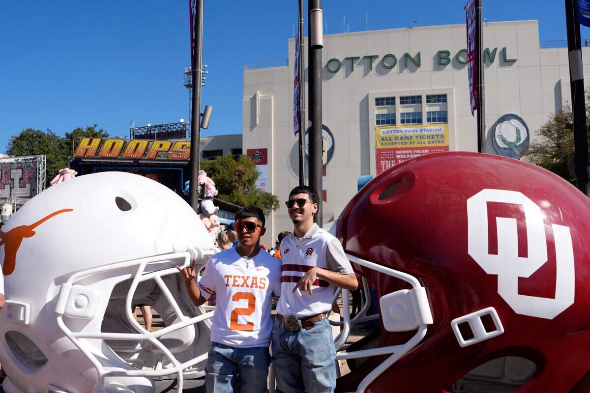 Ronnie Martinez, right, and Joel Arana take a picture in front of the Cotton Bowl the Red River Rivalry college football game between the University of Oklahoma Sooners and the Texas Longhorn at the Cotton Bowl Stadium in Dallas, Texas, Saturday, Oct. 11, 2025.