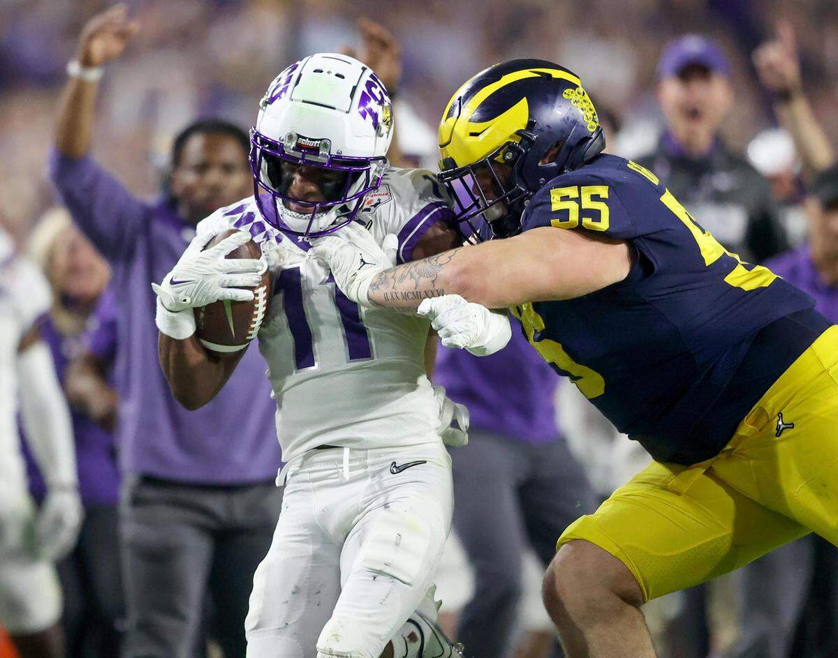 TCU wide receiver Derius Davis is pushed out of bounds by Michigan defensive tackle Mason Graham at the Vrbo Fiesta Bowl at State Farm Stadium in Glendale, Ariz., on Saturday, December 31, 2022.