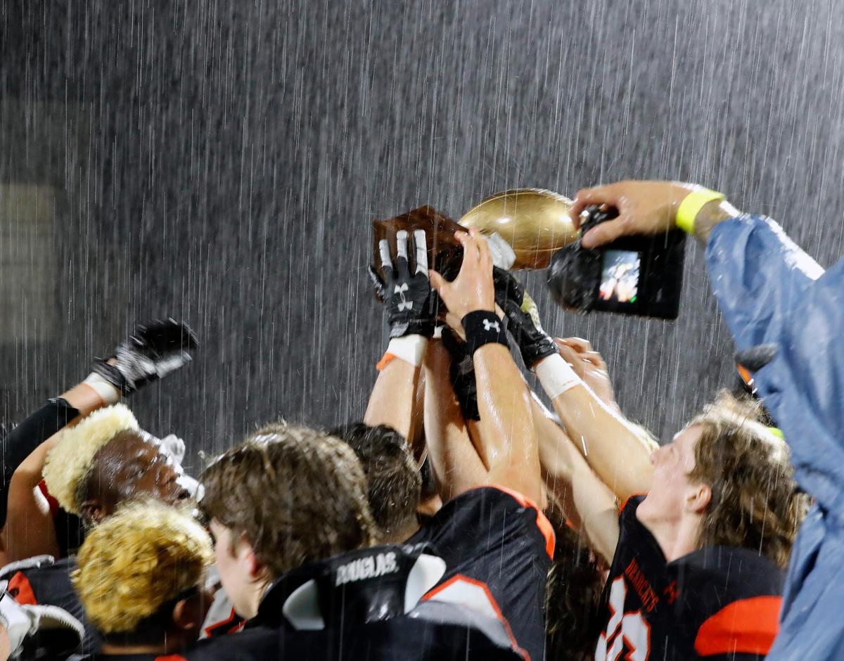 The Aledo Bearcats celebrate their Semi’s trophy in the rain after a UIL Class 5A D1 state semifinal football game at the John Kincaide Stadium in Dallas, Texas, Saturday, Dec. 10, 2022. Under two hours of weather delays Aledo defeated Longview 17-14. (Special to the Star-Telegram Bob Booth)