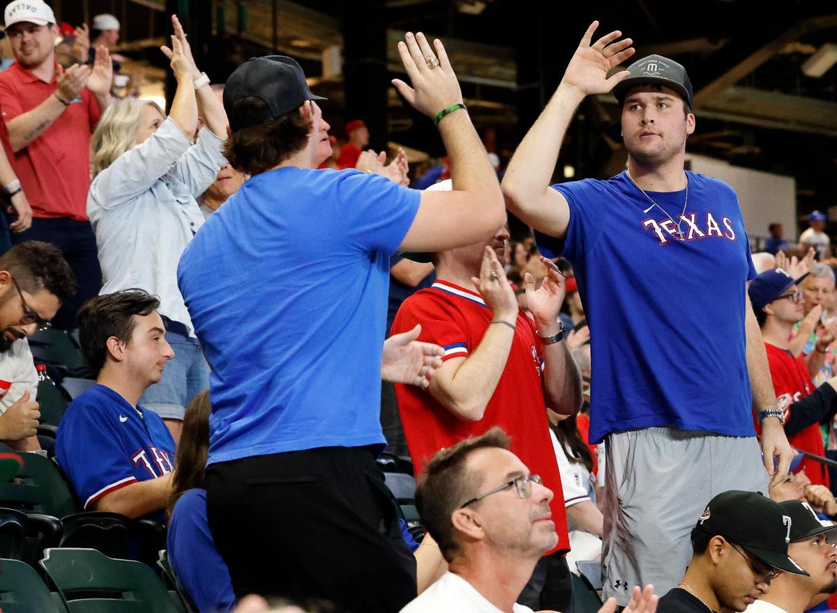 Fans high fives after the Rangers scored a run during the ACLS game 7 watch party at Globe Life Field in Arlington, Texas, Friday, Oct. 23, 2023. Rangers led 4-1 in the top of the third. (Special to the Star-Telegram Bob Booth)