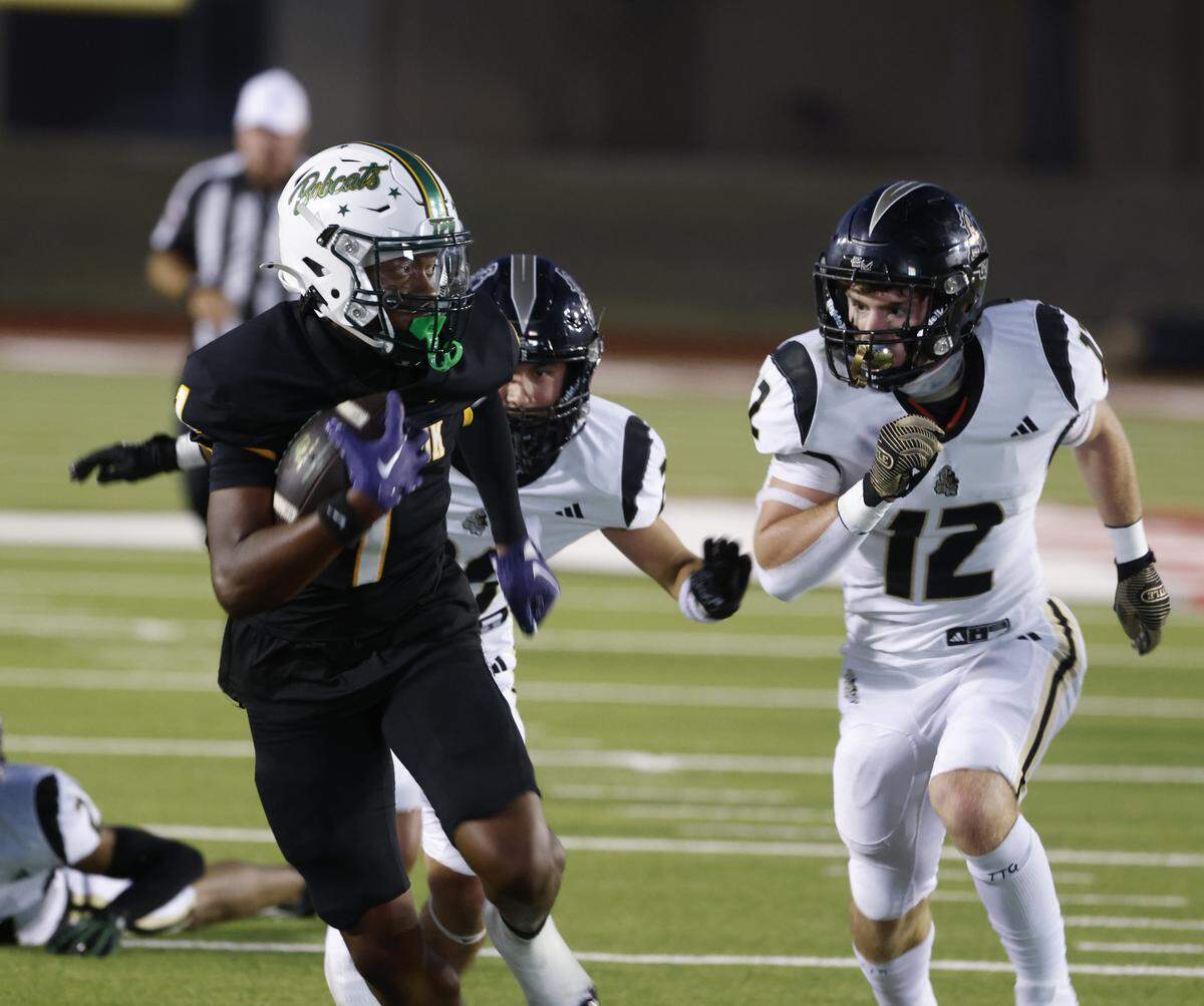 Benbrook wide receiver Waylin Barton (1) is chased down field by Eagle Mountain defenisve back Gavin Trevino (20) and linebacker Matthew Neill (12) during the first half of a UIL football game between Eagle Mountain and Benbrook at Farrington Field in Fort Worth, Texas, Friday, Sept. 26, 2025.