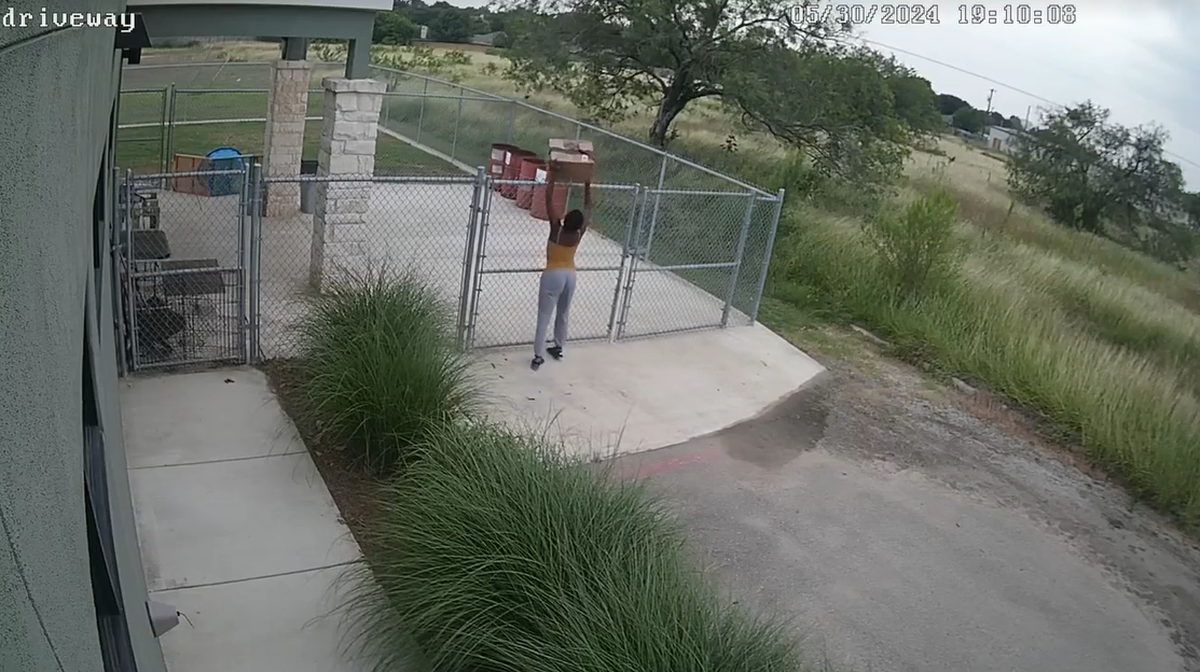 A woman dumps a box with a cat inside at the China Grove Veterinary Clinic in San Antonio, Texas.