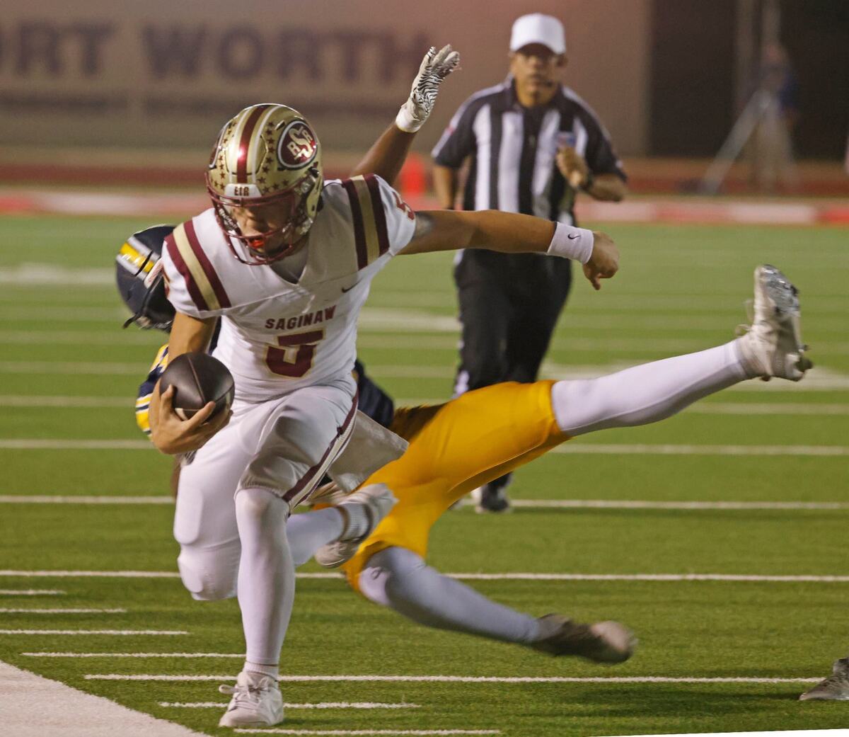 Saginaw quarterback Roman Morales (5) is run out of bounds by Arlington Heights defense Kelle Johnson (44) during a District 4-5A D1 football game at Farrington Field in Fort Worth, Texas, Thursday, Oct. 10, 2024. (Special to the Star-Telegram / Bob Booth)