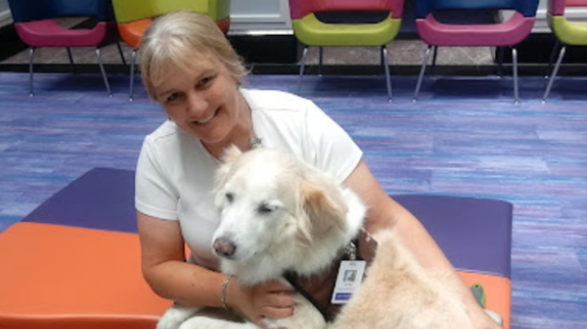 Dog masseuse Krista Doyle enjoys a moment with her late dog Sunny, the subject of some books she has written.