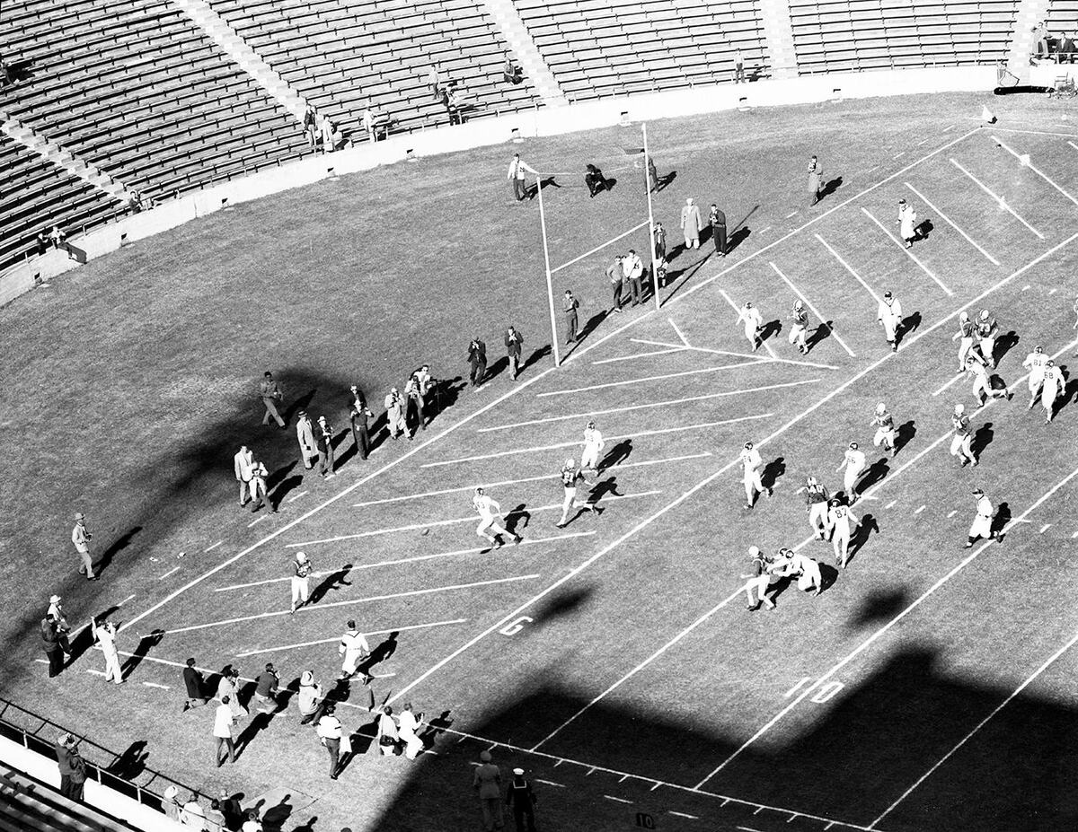 Despite pressure from two Texas Christian University tacklers Don Meredith gets off a touchdown pass to Tirey Wilemon in 1958.