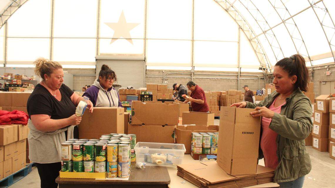 Volunteers at Mission Arlington on Tuesday assemble turkey baskets for the faith-based nonprofit’s Thanksgiving day distribution.