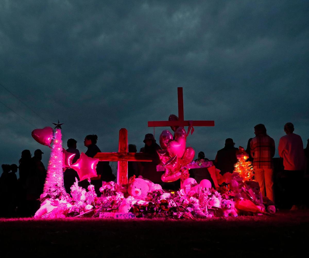 A memorial bathed in pink light stood on a hill during a vigil for 7-year-old Athena Strand at the First Baptist Church of Cottondale.