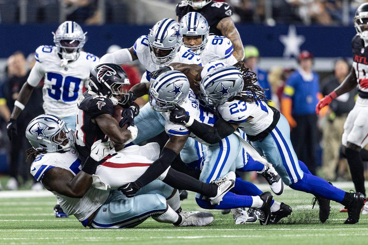 Cowboys defense gang tackles Falcons running back Lamar Jackson (38) in the first half of an NFL preseason game between the Dallas Cowboys and the Atlanta Falcons at AT&T Stadium in Arlington on Friday, Aug. 22, 2025,