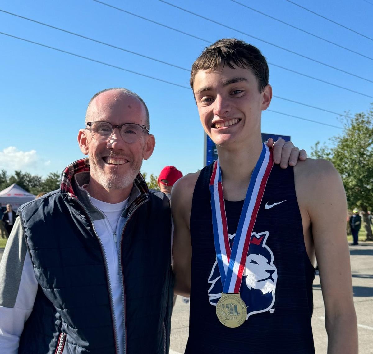 Ethan Gonzalez poses with Richland cross country head coach Mark Ashley after winning the Class 5A state championship.