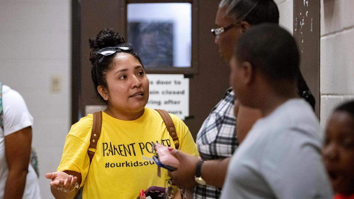 Amy Solis, a member of the Powerful Parents Movement, talks to a parent during a back-to-school fair about the state of schools in Fort Worth, Texas, on Saturday, Aug. 13, 2022.