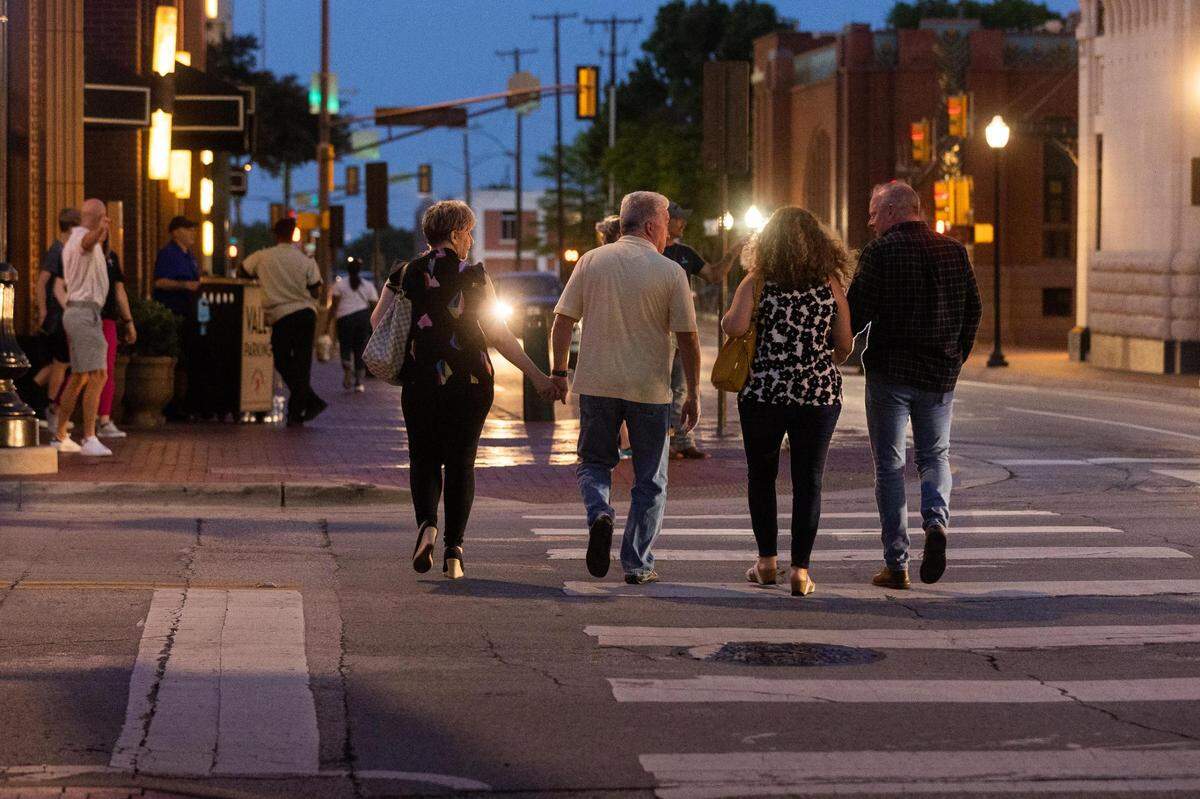 People walk across Commerce Street on Saturday, May 7, 2022, in downtown Fort Worth.