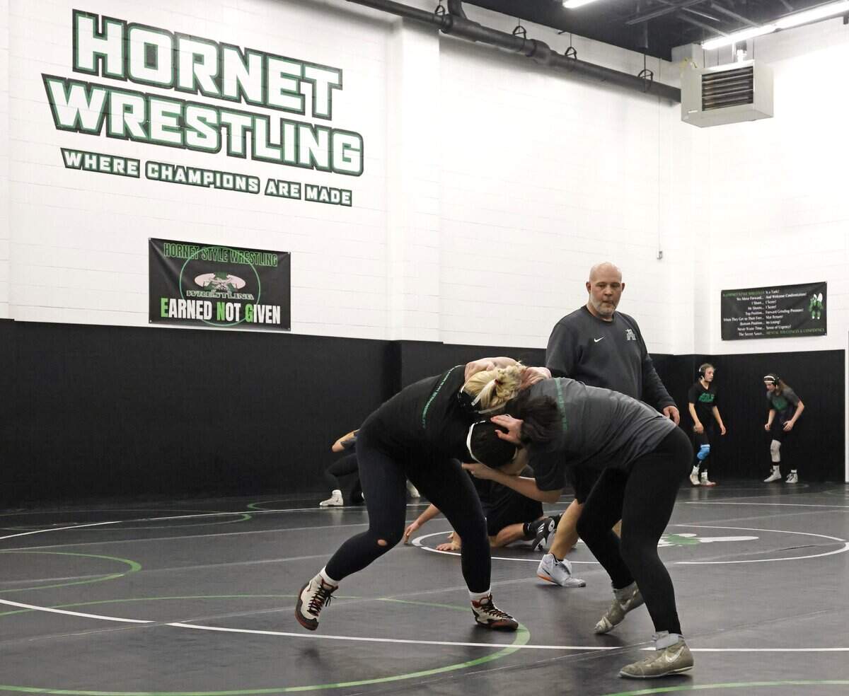 Axle girls head wrestling coach Jayson Conger keeps an eye on wrestlers during one of the final practices before the state championship meet at Azle High School in Azle, Texas, on Friday, Feb. 9, 2026.