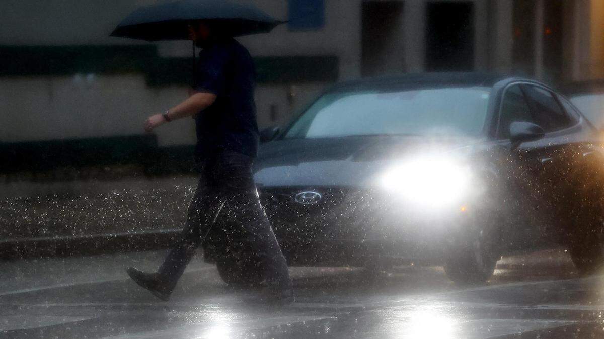 A pedestrian crosses the street in downtown Fort Worth on Monday morning as rain continues to fall in the DFW area on August 22, 2022.