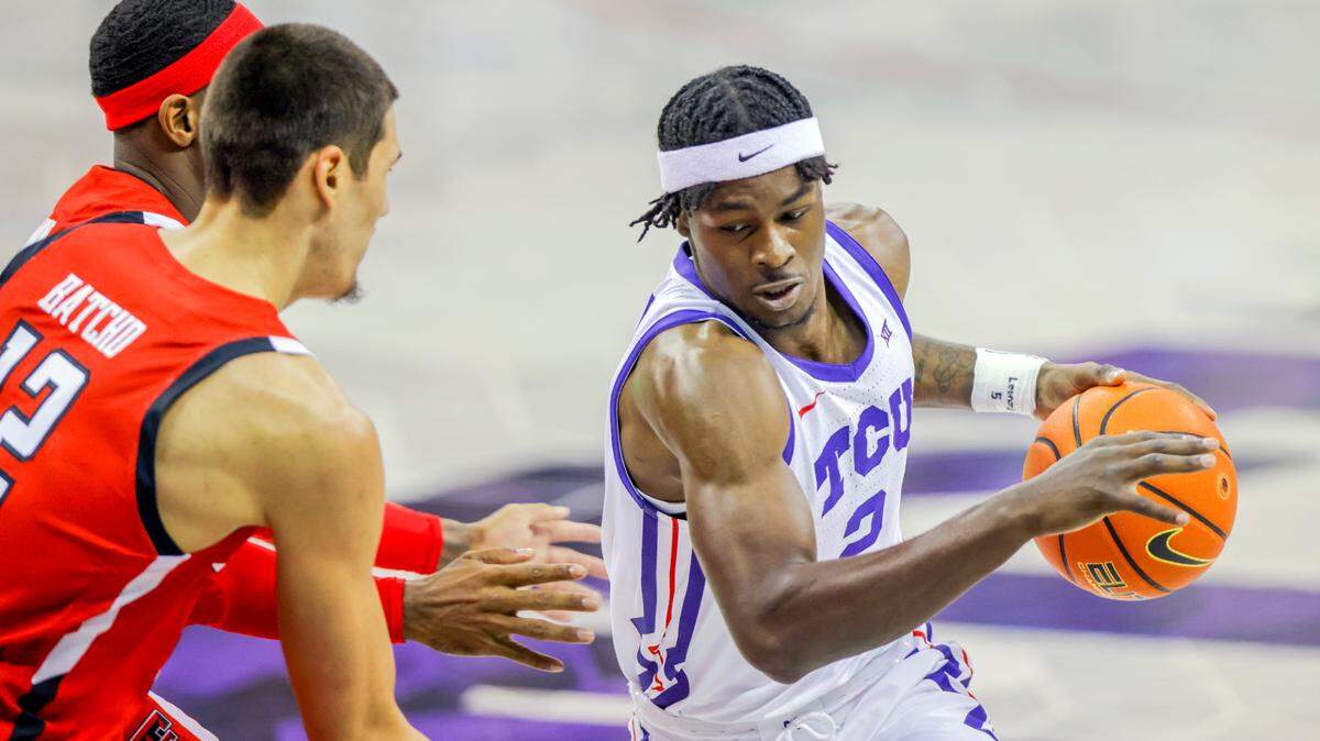TCU forward Emanuel Miller (2) drives to the basket against Texas Tech defenders Daniel Batcho, front left, and De’Vion Harmon, back left, during the first half of an NCAA college basketball game on Saturday.