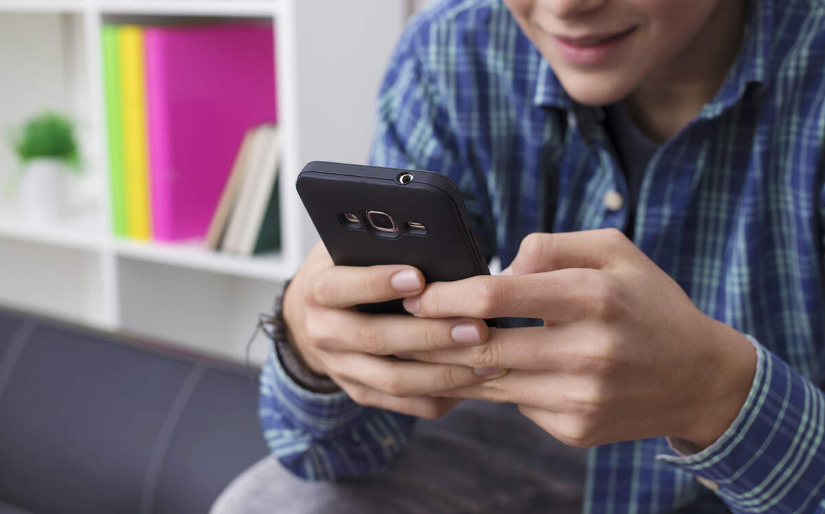 A teen using a cellphone.