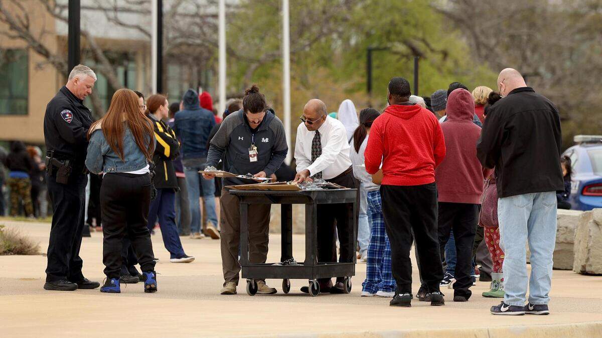 School officials and Arlington police assist families in being reunited with students at the Arlington ISD Athletic Center on Monday, March 20, 2023. Two students were shot Monday morning at Lamar High, causing a lockdown. Arlington police arrested a 15-year-old student suspected in the shooting.