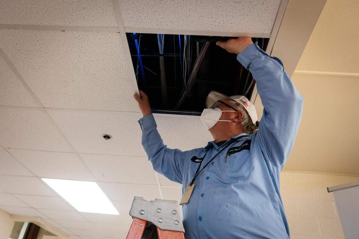 Mitch Jones checks the ducts in preparation for the winter storm Wednesday, Feb. 2, 2022, at Worth Heights Elementary in Fort Worth. Area child centers also are making preparations.