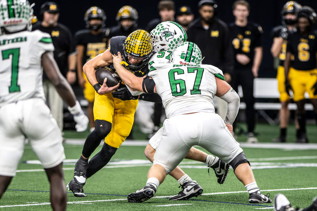 Miles Godwin (57) and John Worthington (67) of Paradise stop Malakoff quarterback Mike Jones (12) for a short gain in a Class 3A Division 1 state quarterfinal on Thursday, Dec. 12, 2024 at the Ford Center in Frisco, Texas.