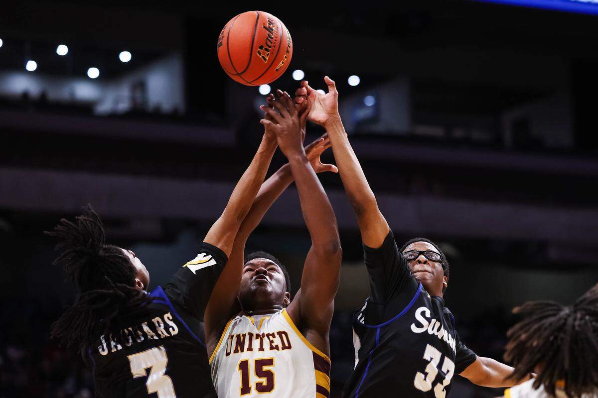 Mansfield Summit guards Javon Ross (33) and David Bardere II (3) reach their arms up in attempt to grab a rebound over the hands of a Beaumont United player in the Class 5A Division II state championship at The Alamodome in San Antonio, Texas, March 14, 2026.