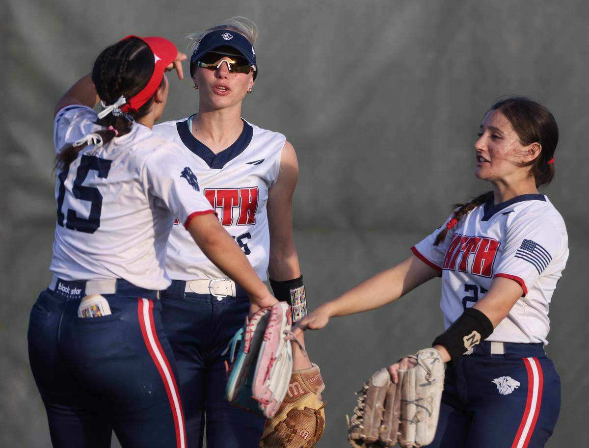 Grapevine Faith center fielder Michaela Hamilton (16), Alexandria Ciccone (15) and Hannah Smeltzer (23) celebrate in the outfield during a softball game at Oak Grove Park in Grapevine, Tx. Tuesday, March 31, 2026