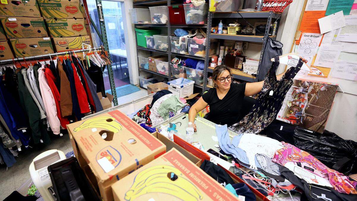 Volunteer Marisol Cabello sorts clothes in the workroom of Eastside Ministries in Fort Worth. Eastside Ministries provides access to food, clothing and other services, like counseling and money management classes.