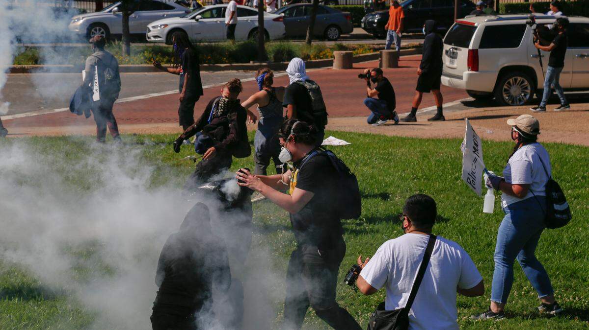 A demonstrator in Dallas put a tear gas canister in a plastic trash bag to keep it from affecting other demonstrators May 30. The demonstrators protested police brutality follow the death of George Floyd while he was being arrested my Minneapolis police.